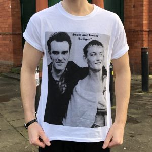 A white T-shirt featuring a rectangular black-and-white picture of Morrissey and the boxer Cornelius Carr. Morrissey (left) has his arm around the boxer (right).