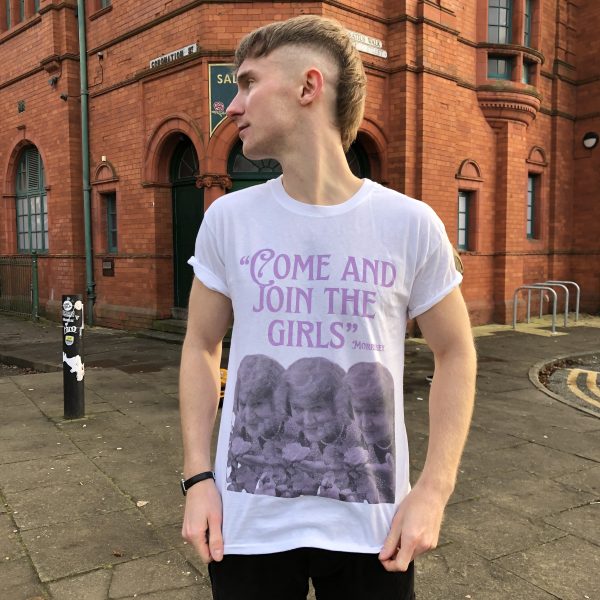 A male model wearing the 'Come And Join The Girls' T-shirt with the Salford Lads Club in the background